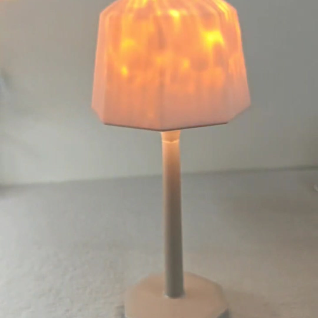 Shade on, lights low: the soft glow on a shelf.